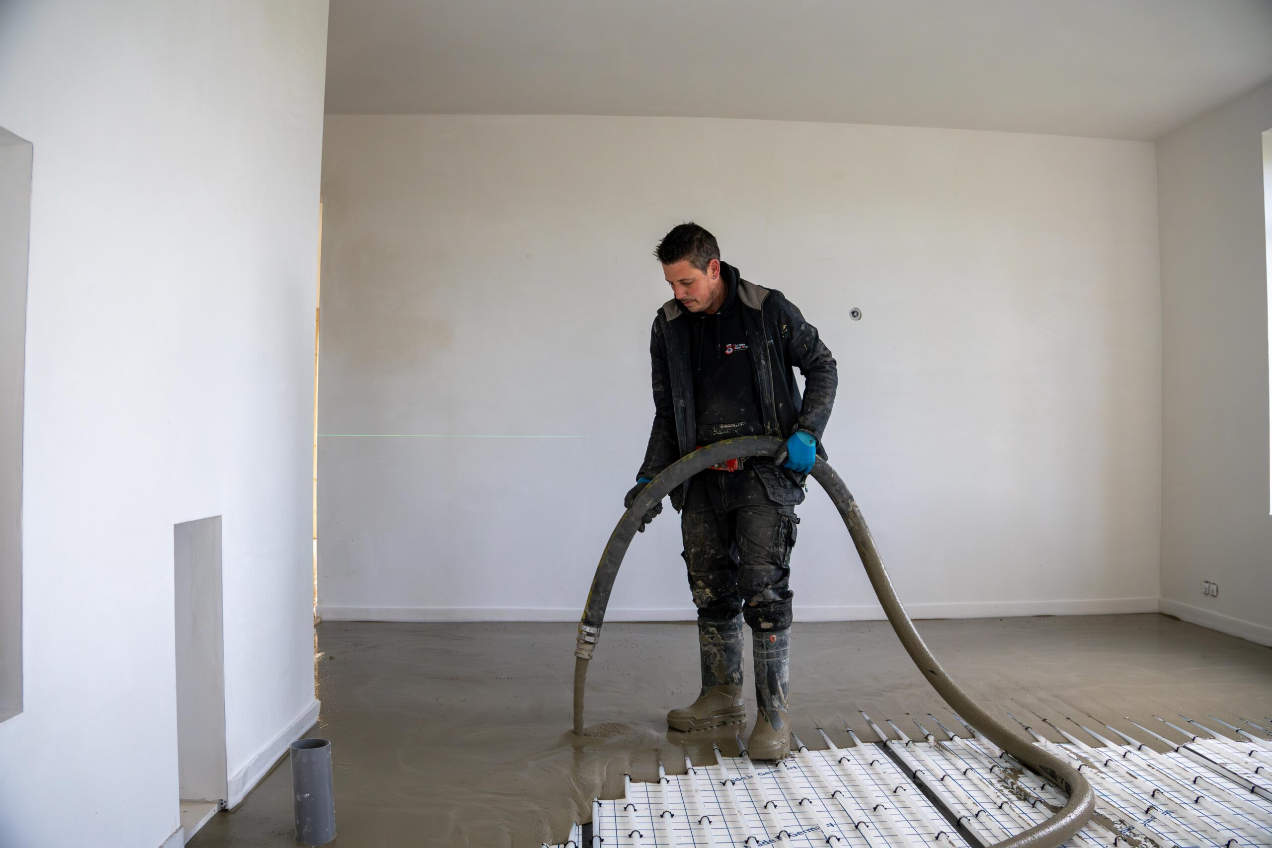 Een man stofzuigt een kamer met tapijt-thermo floor friesland (Oudega)