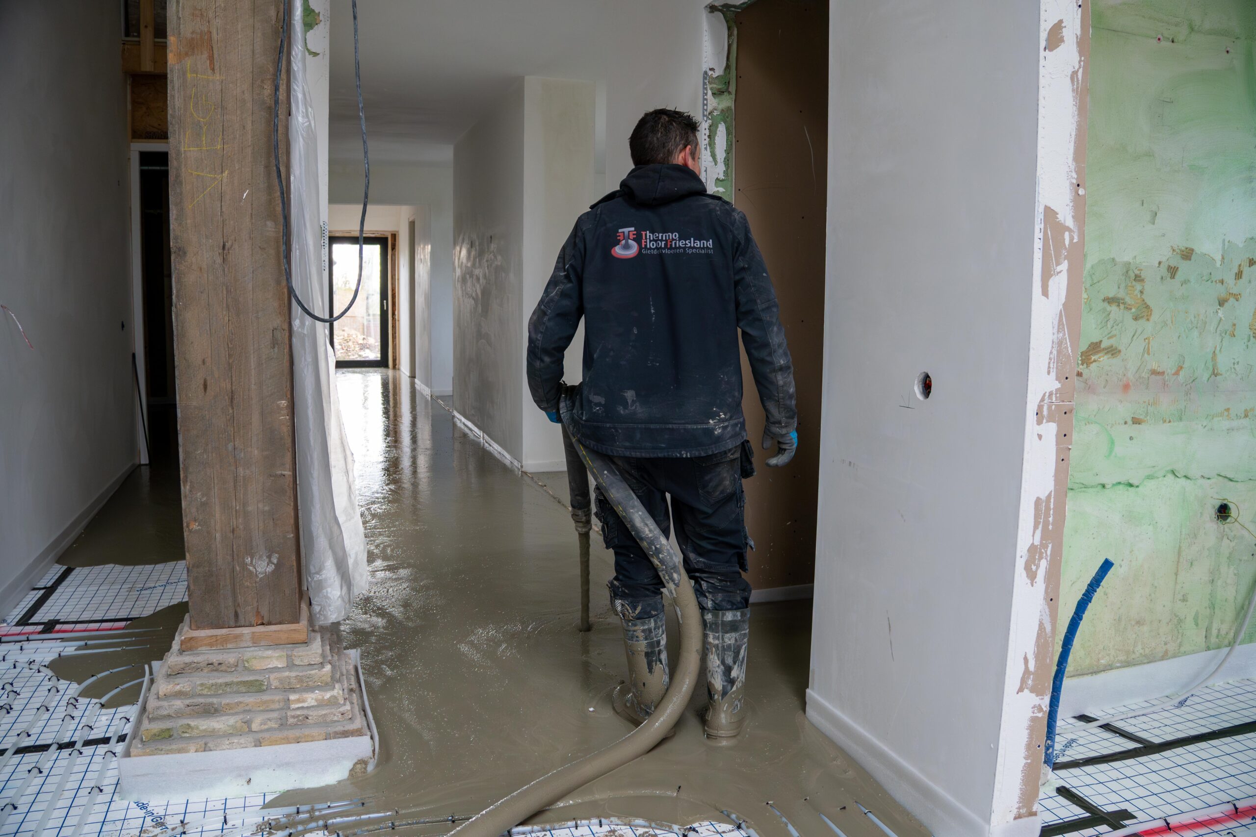 Een man stofzuigt een gang-thermo floor friesland(Oudega)