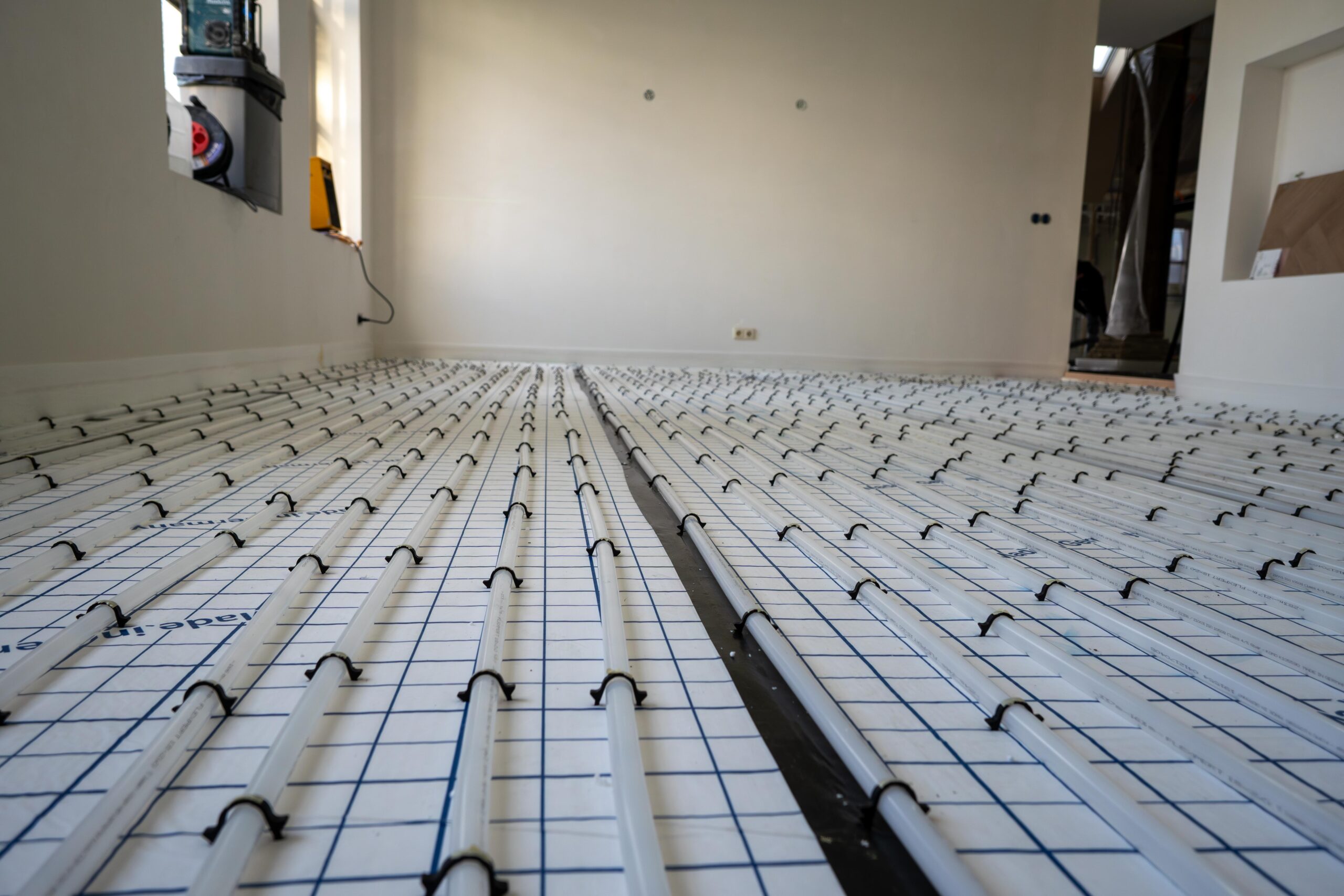 Een kamer met een vloerverwarmingssysteem en een groot roosterpatroon op de vloer – Thermo Floor Friesland (Oudega)
