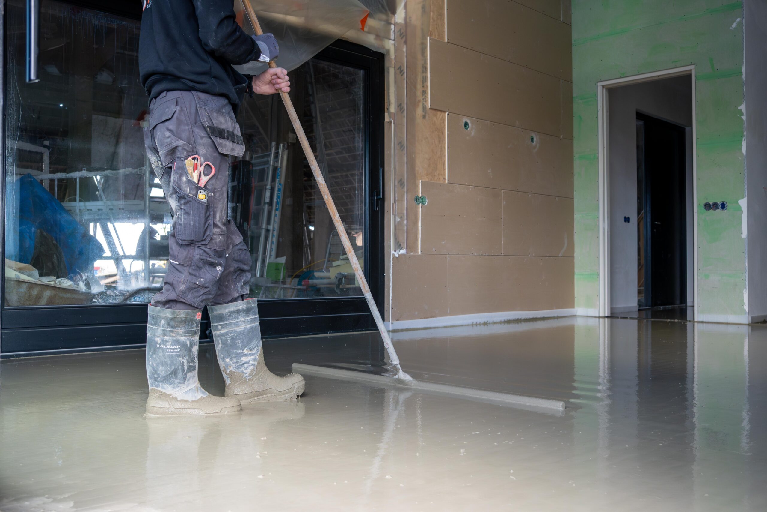 Een man veegt de vloer met een bezem-thermo floor friesland(Oudega)
